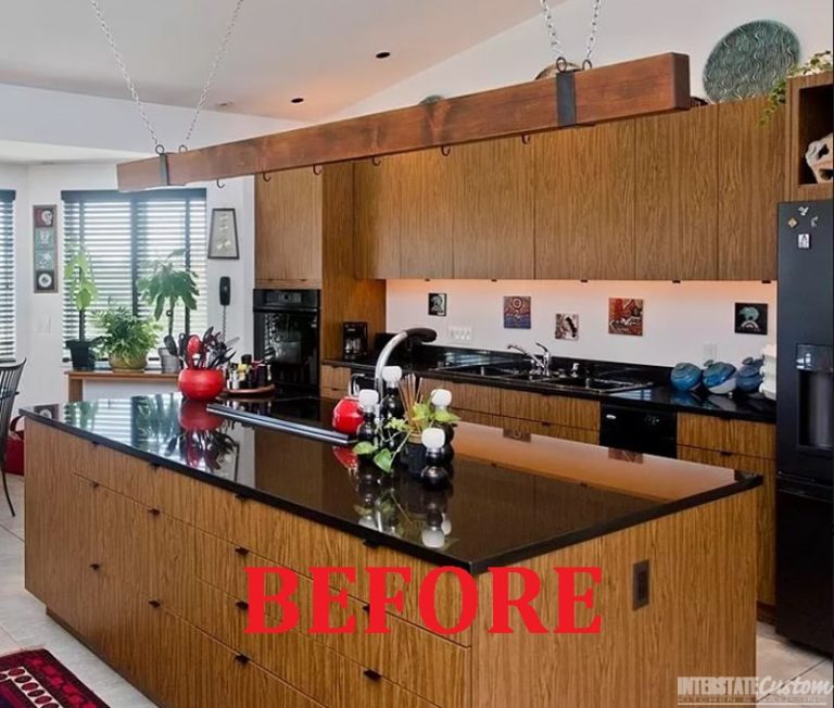 Before image of a kitchen with dark wood cabinetry, black countertops, and a central island with a sink, featuring modern lighting and decorative plants. Project by Interstate Custom Kitchen & Bath, Inc.