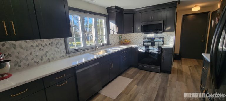 Full view of the Simply Elegant kitchen remodel showing North Point cabinetry in a shaker style maple slate door, Hanstone Chantilly lace quartz countertops, and natural marble braided mosaic tile backsplash. Project by Interstate Custom Kitchen & Bath, Inc.