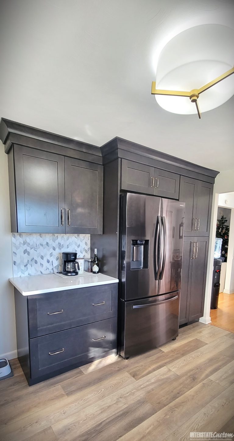 Corner view of the Simply Elegant kitchen remodel highlighting North Point cabinetry in a shaker style maple slate door and Hanstone Chantilly lace quartz countertops. Project by Interstate Custom Kitchen & Bath, Inc.