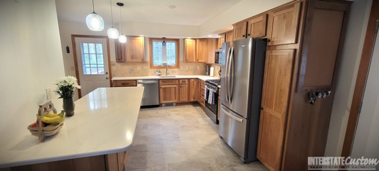 Another angle of the Eat-in Country Kitchen remodel with a focus on the Hickory Harvest shaker door cabinetry, stainless steel appliances, and bar area. Project by Interstate Custom Kitchen & Bath, Inc.