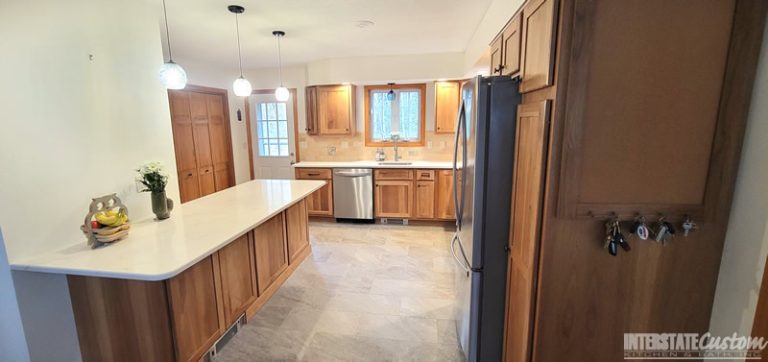 Eat-in Country Kitchen remodel with a large peninsula featuring Spectrum Indulgence Quartz countertops, Hickory Harvest shaker door cabinetry, pendant lighting, and stainless steel appliances. Project by Interstate Custom Kitchen & Bath, Inc.