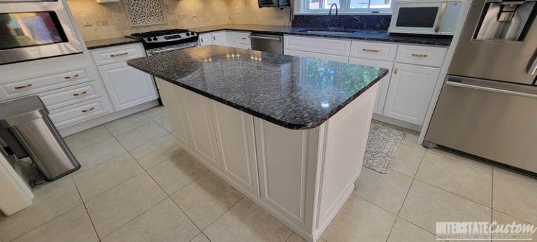 Close-up of the kitchen island with sapphire blue granite countertop and white painted raised panel cabinets in the traditional kitchen remodel. Project by Interstate Custom Kitchen & Bath, Inc.