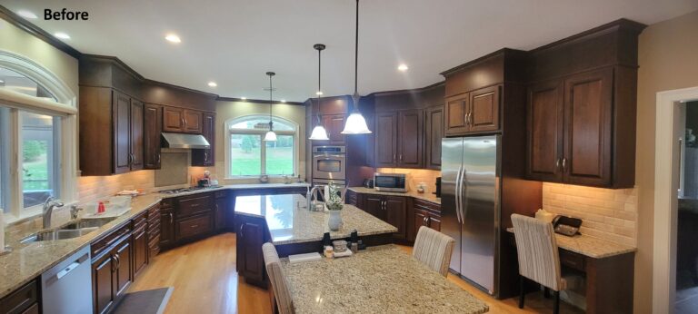 Outdated kitchen with dark wood cabinets, granite countertops, and stainless steel appliances prior to remodel