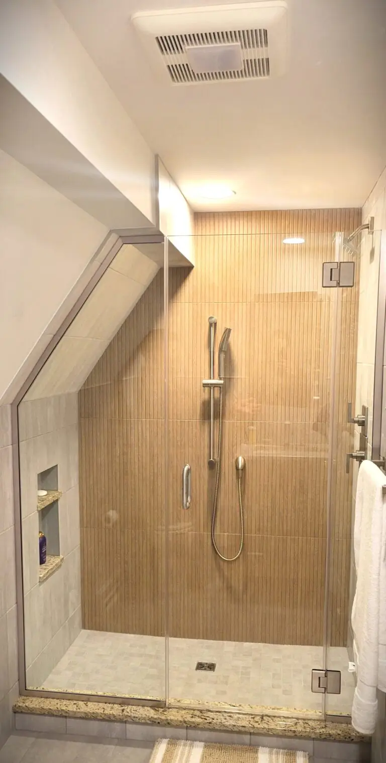 Updated bathroom vanity with wood cabinet, granite countertop, modern faucet, and tiled walls