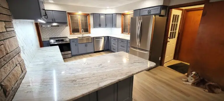 Modern kitchen remodel with gray shaker cabinets, quartz countertops, stainless steel appliances, and peninsula seating