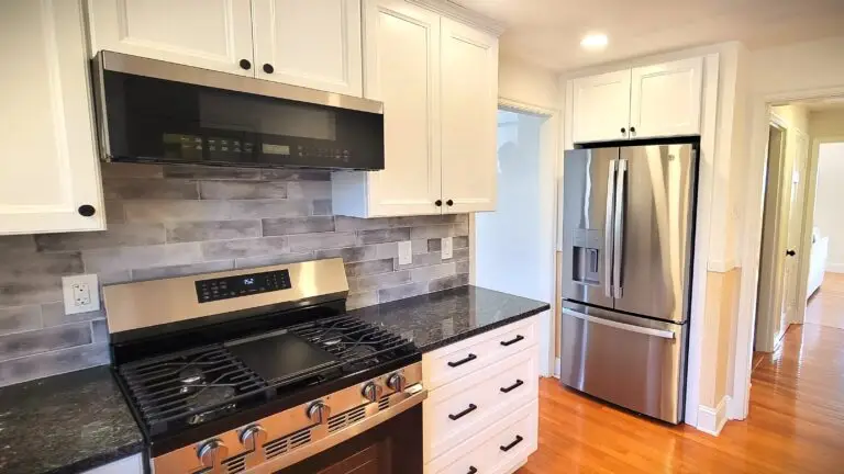 After kitchen with white shaker cabinets, gray granite countertops, and stainless steel appliances in Longmeadow MA
