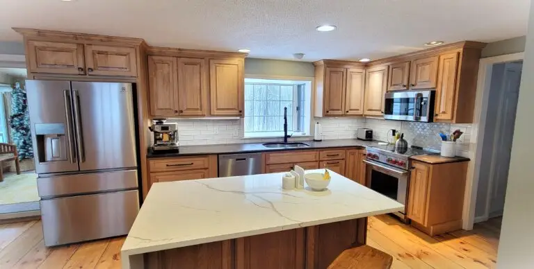 After kitchen wide view showing cabinet refacing, new island with drawers, and quartz waterfall edge in East Longmeadow MA