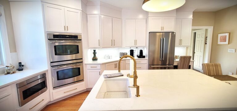Updated kitchen design with white cabinets, built-in appliances, quartz countertops, and hardwood floors