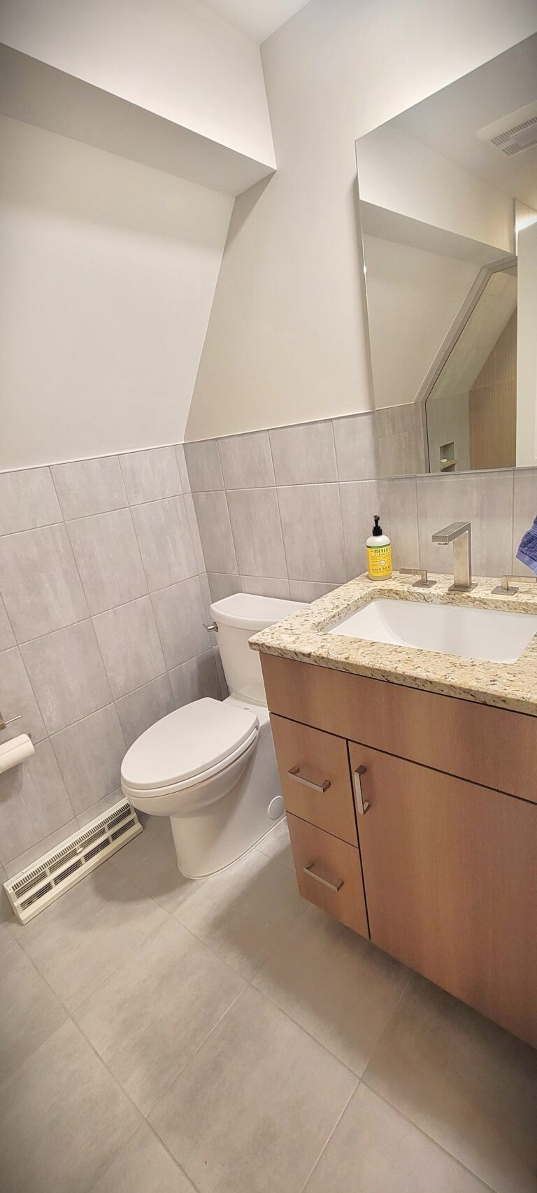 Renovated bathroom with walk-in glass shower, tile surround, and built-in niche shelving