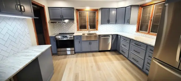 Kitchen renovation with gray shaker cabinets, large peninsula, stone accent wall, and open layout
