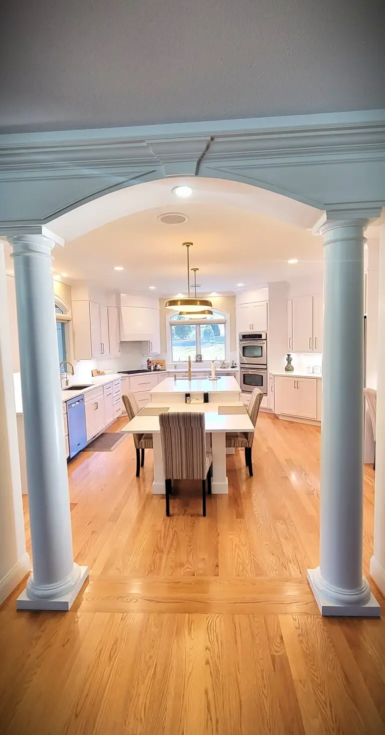 Open concept kitchen remodel with white shaker cabinets, large island, gold hardware, and recessed lighting