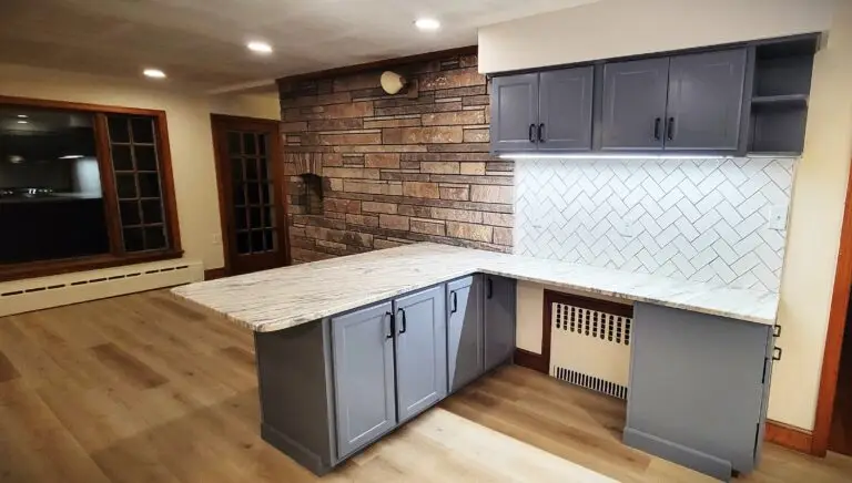 Bright kitchen upgrade featuring gray cabinets, quartz countertops, stainless steel appliances, and wood-look flooring