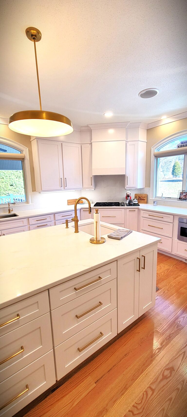 Luxury kitchen upgrade featuring white shaker cabinets, quartz countertops, gold fixtures, and spacious island