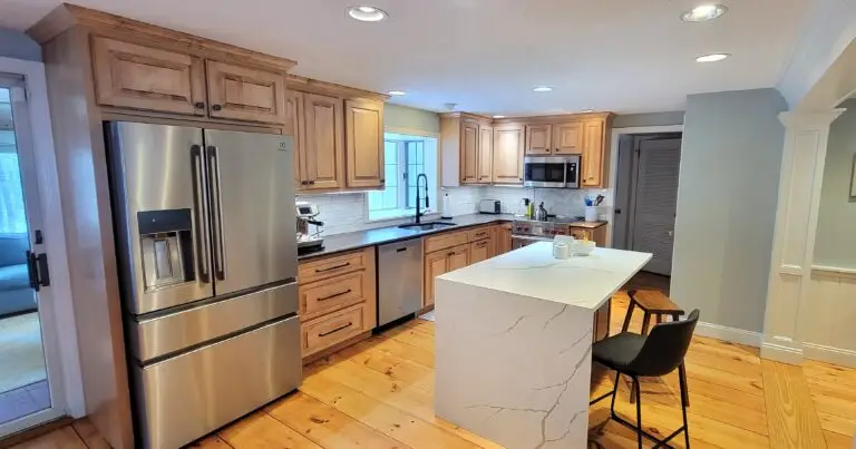 Finished kitchen with refaced Honey Maple cabinets, quartz waterfall island, and custom tile backsplash in East Longmeadow MA