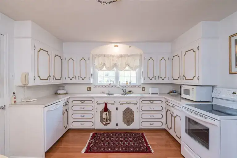 Before kitchen wide view with traditional white cabinets and hardwood flooring in Longmeadow MA